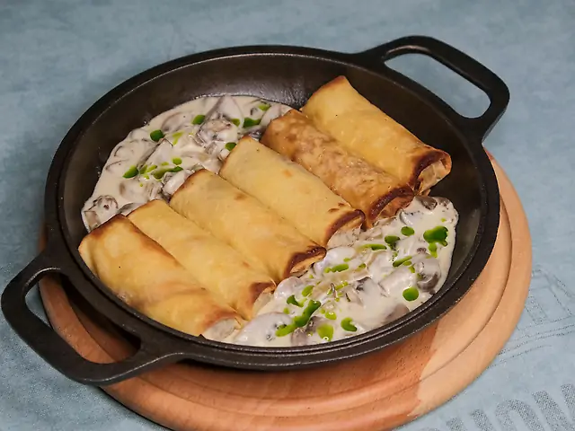 Млинці з мясом у вершковому соусі та печерицями